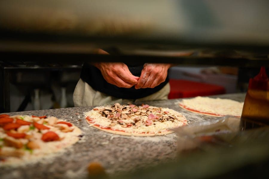 A pizza base being stretched by hand