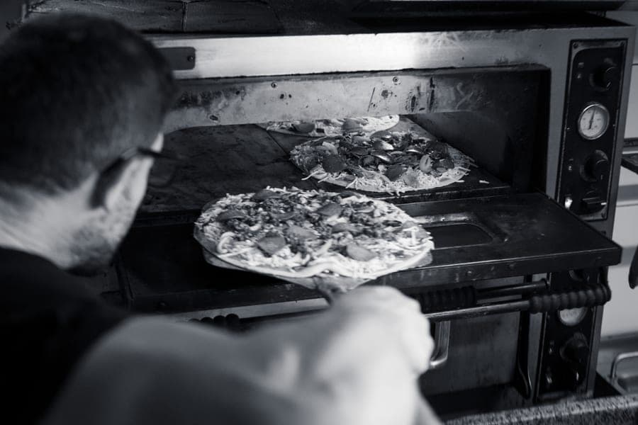 Pizzas cooking in the stone oven